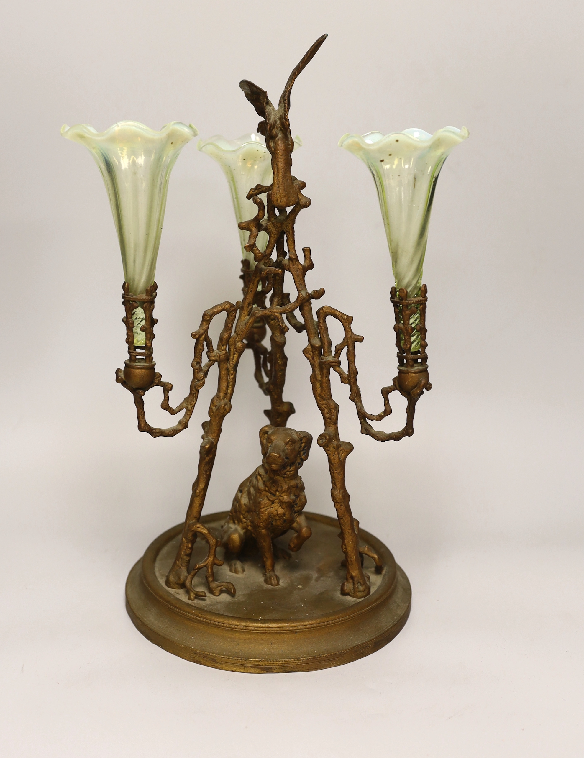 A gilt-metal three-branch epergne with seated dog and three opalescent green glass flutes, 41cm high